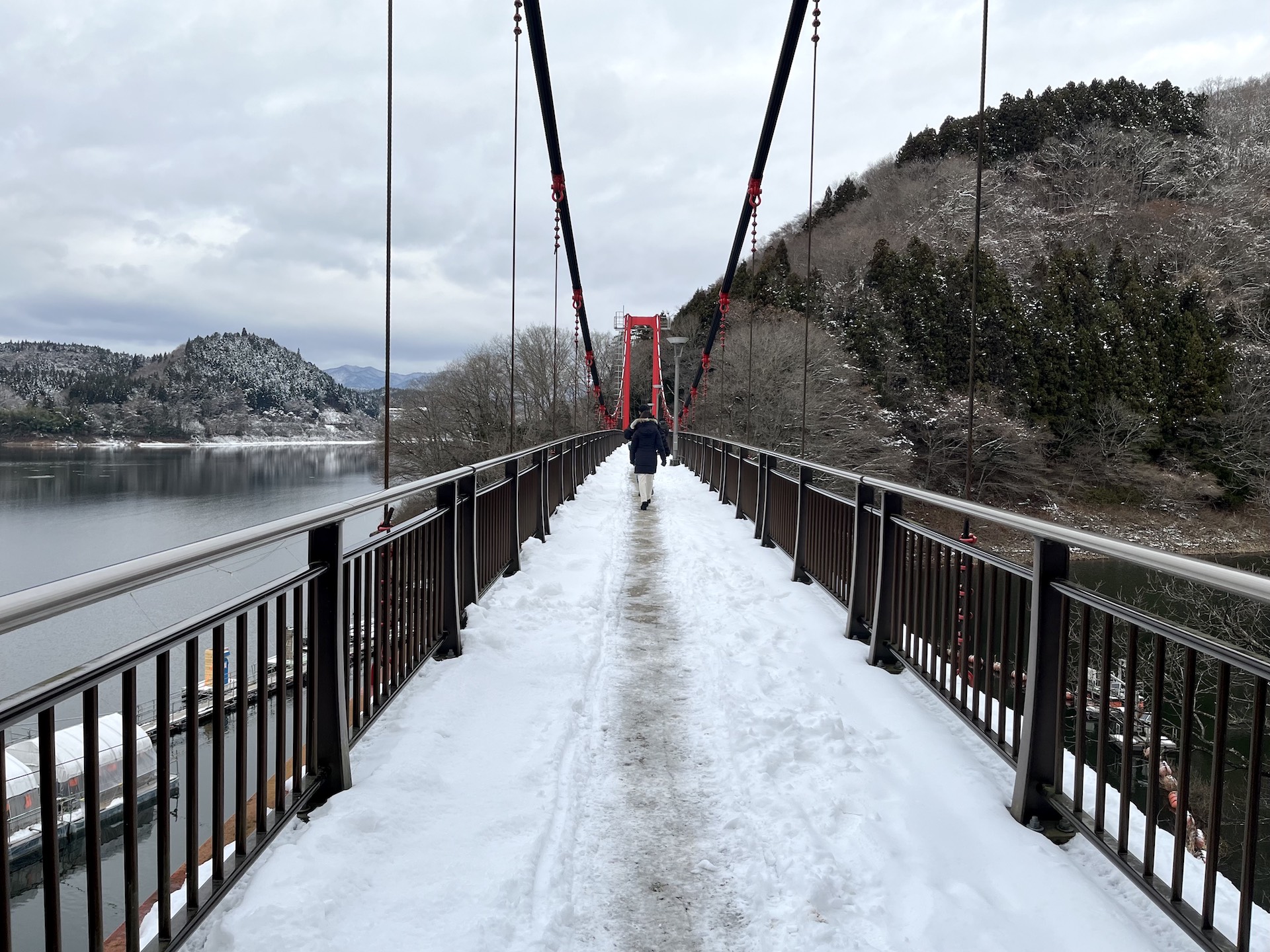 雪の絨毯が敷かれた赤色の合道吊橋を渡り、ドーム船へと向かう