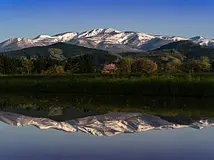 水面にくっきりと映る姿が美しい、春の栗駒山