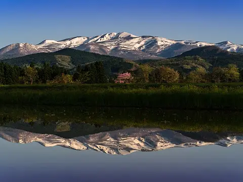 水面にくっきりと映る姿が美しい、春の栗駒山